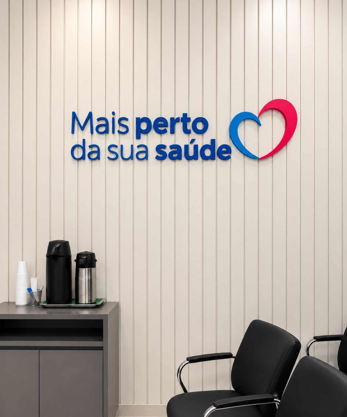 Recepção da Corbe, com a frase Mais perto da sua saúde e o coração na parede ripada, balcão com cantinho do café e cadeiras de espera
